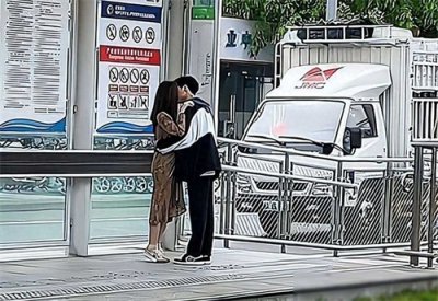 ​情侣车站下拥吻回顾，女生路过驻足观看，情侣一脸尴尬，捂脸苦笑